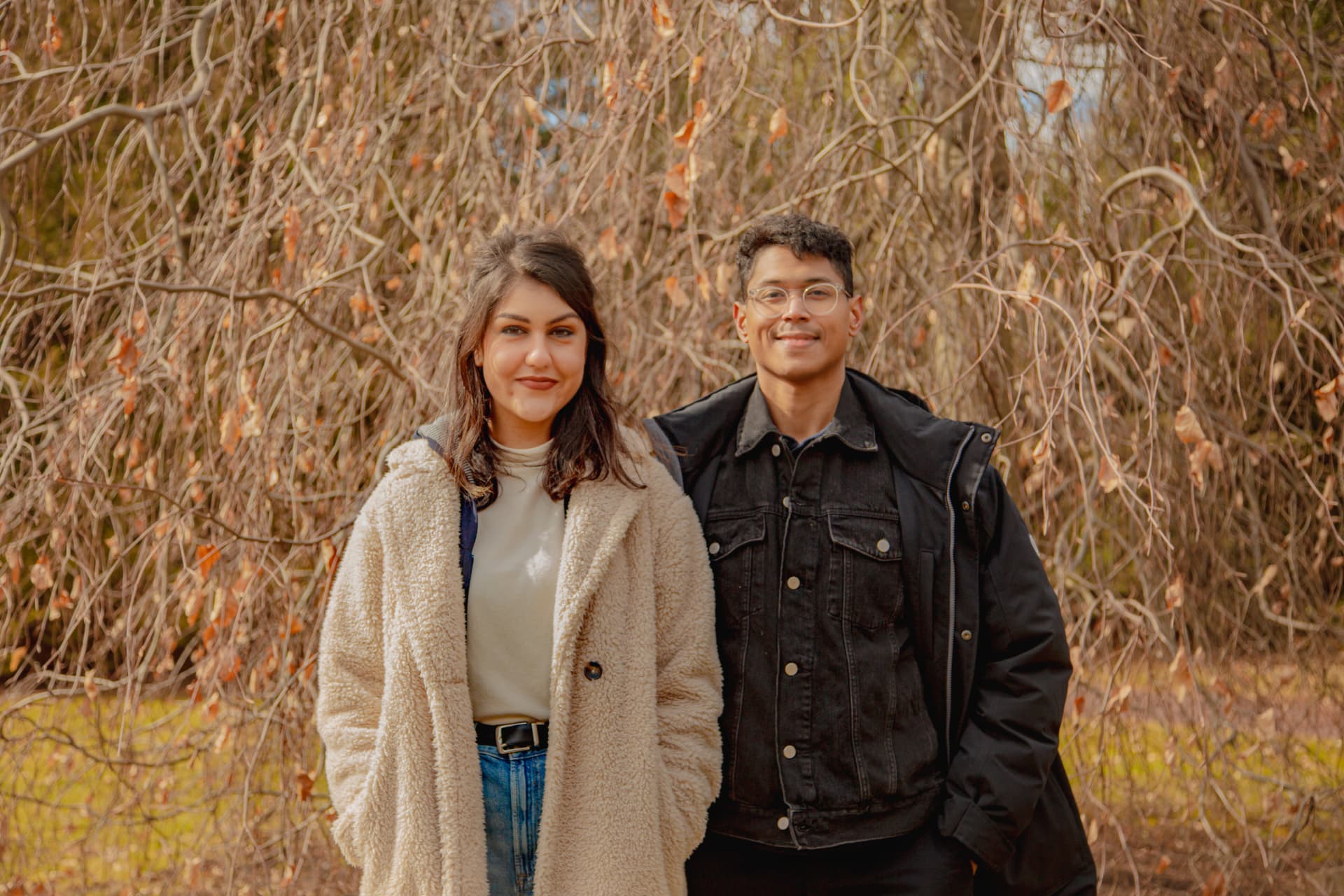 Mitra and Corey standing beneath a willow in the winter light
