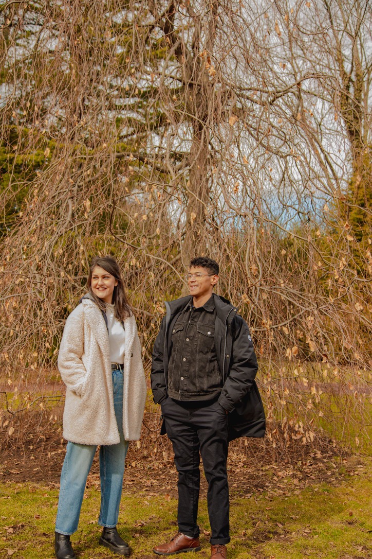 Mitra and Corey standing together under a bare tree in the countryside